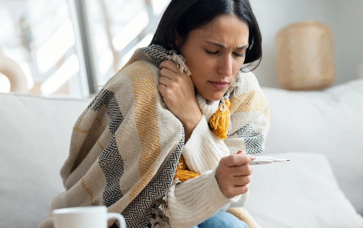Eine weibliche Person der offentlichlich Kalt ist in eine Decke gehüllt